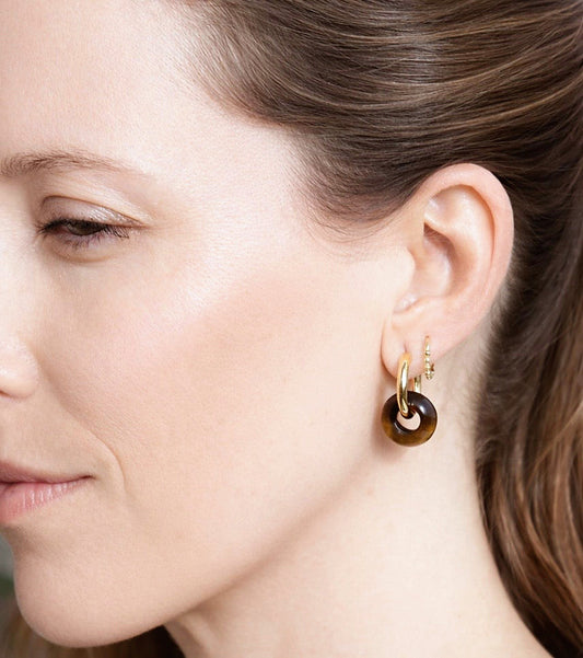 Pendientes Pia puestos en la oreja, aros dorados con colgante de piedra natural marrón