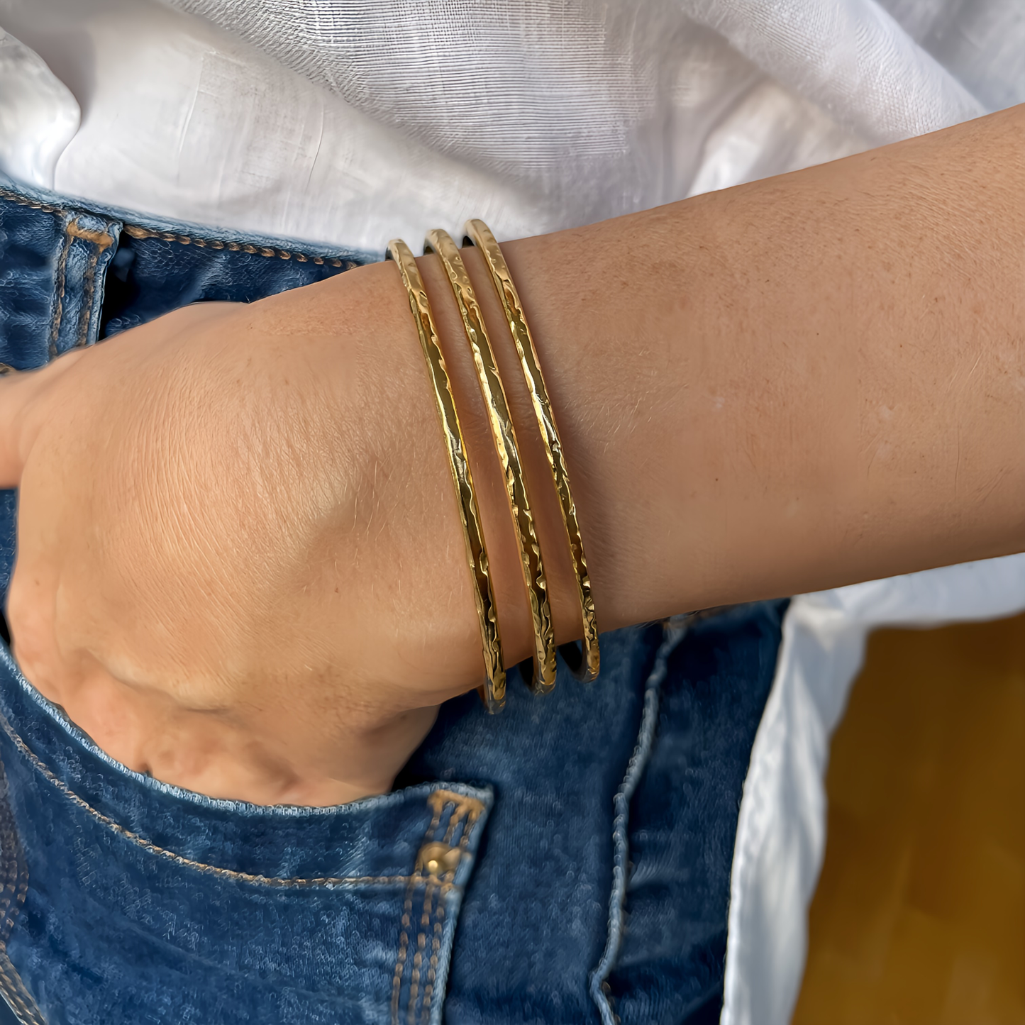 BRAZALETE FABIOLA. Brazalete rígido ajustable de acero inoxidable bañado en oro de 18k