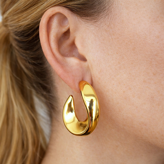 Pendientes Emiliana puestos en la oreja, aros de acero inoxidable bañados en oro de 18K