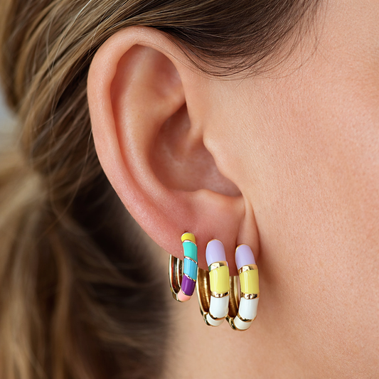 Pendientes Gabriela puestos en la oreja, aros bañados en oro con esmalte multicolor