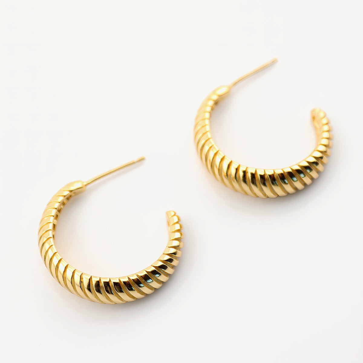 Pendientes Leonora, par de aros bañados en oro de 18K con textura acanalada, vista de cerca