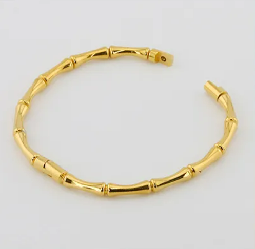 BRAZALETE VALLE. Brazalete rígido de acero inoxidable bañado en oro