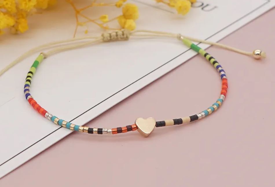 PULSERA MARGARITA. Pulsera ajustable de cuentas multicolor con corazón pequeño dorado
