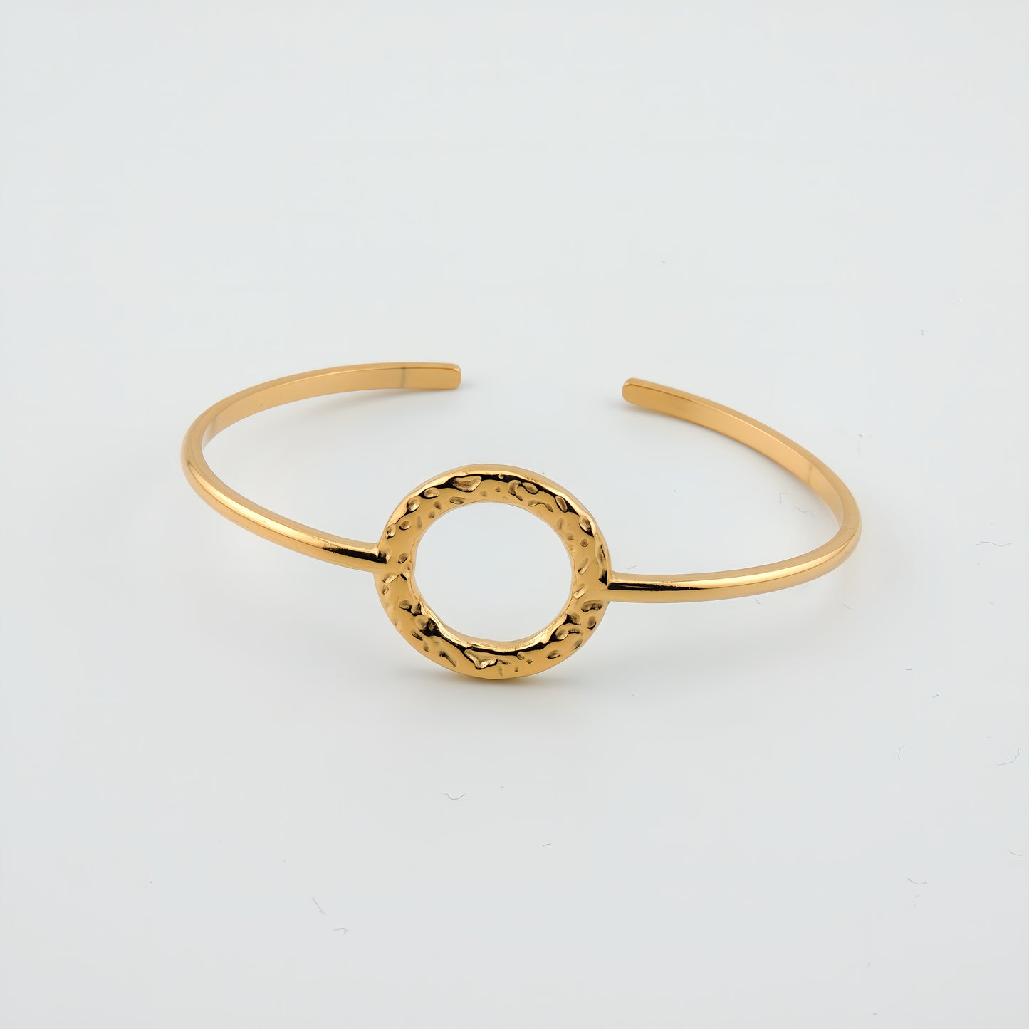 BRAZALETE MACARENA. Brazalete rígido ajustable de acero inoxidable bañado en oro de 18k