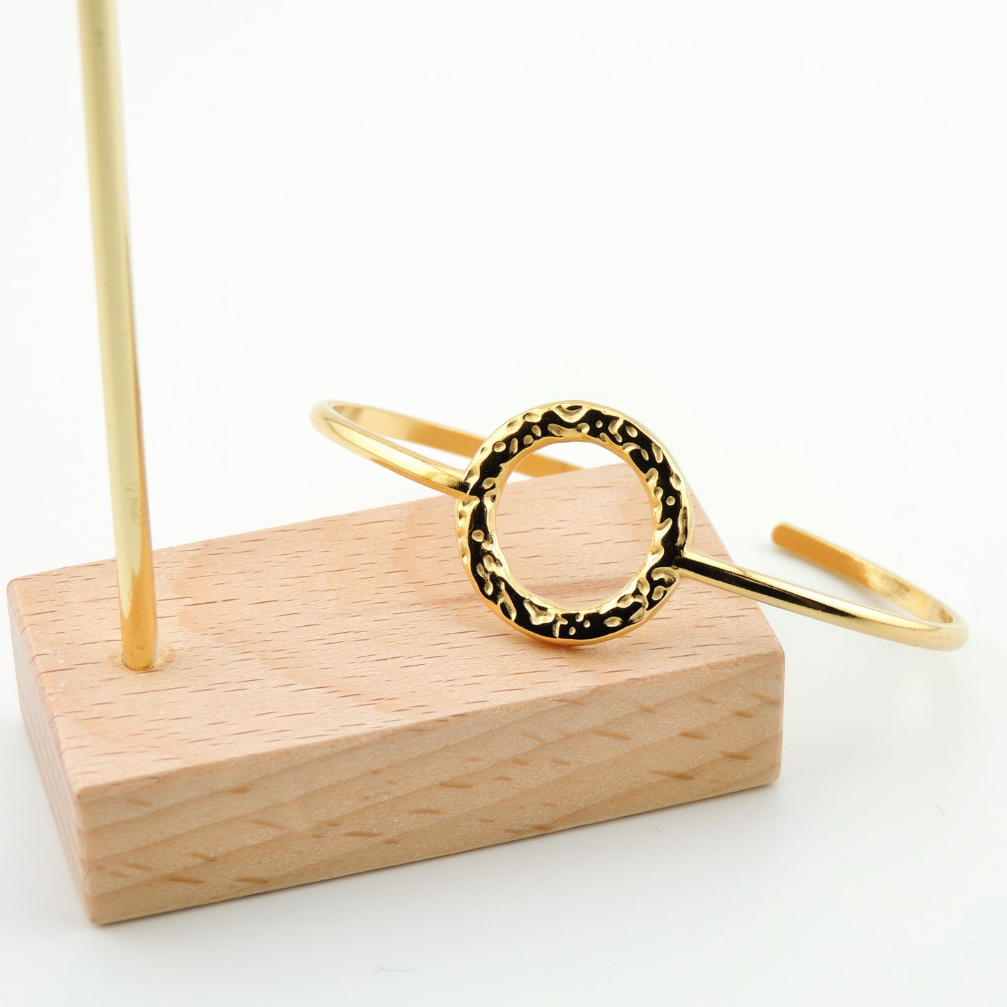 BRAZALETE MACARENA. Brazalete rígido ajustable de acero inoxidable bañado en oro de 18k