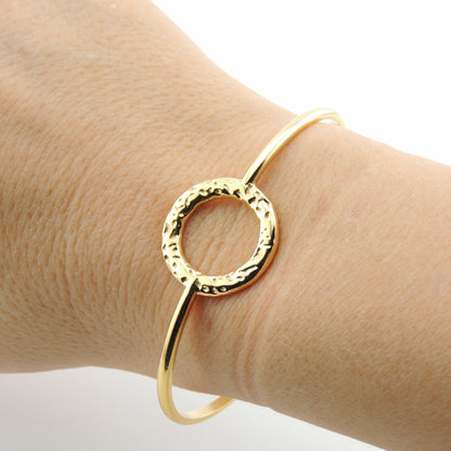 BRAZALETE MACARENA. Brazalete rígido ajustable de acero inoxidable bañado en oro de 18k