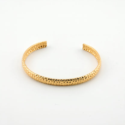 BRAZALETE NINES. Brazalete rígido ajustable de acero inoxidable bañado en oro de 18k