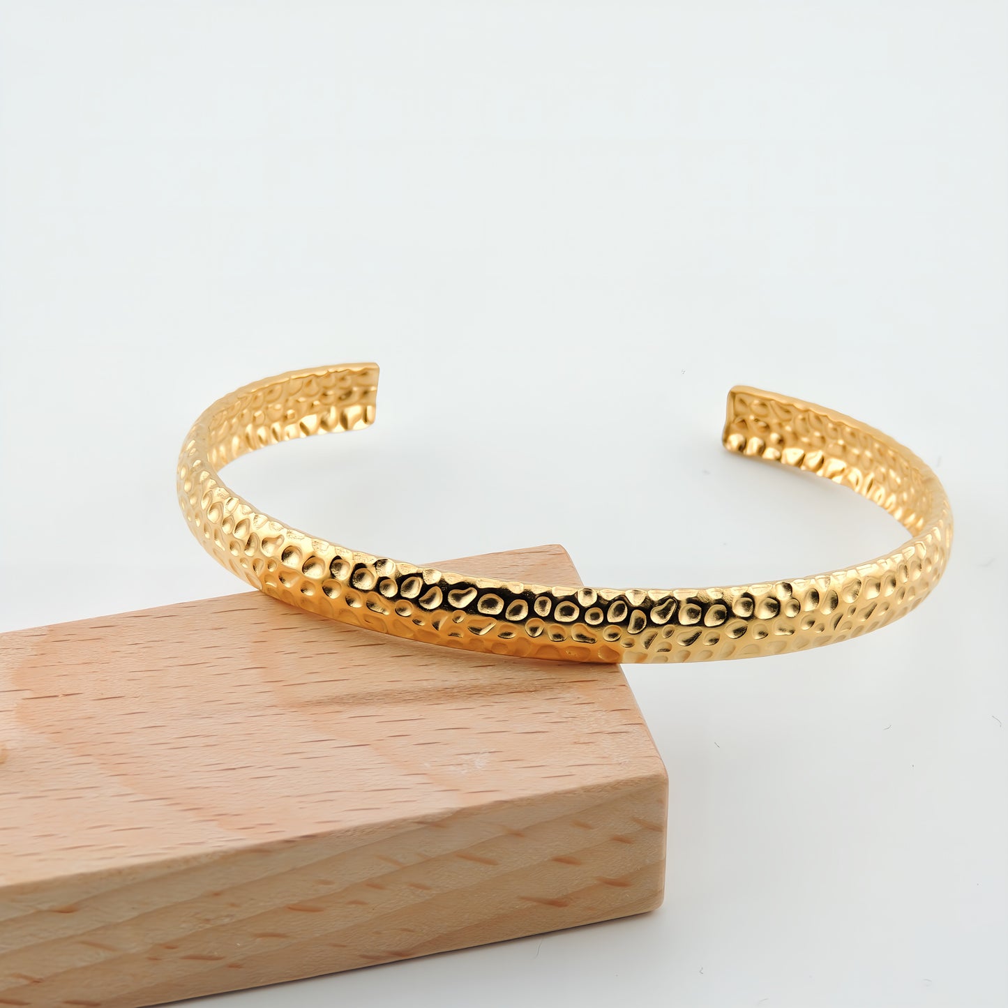 BRAZALETE NINES. Brazalete rígido ajustable de acero inoxidable bañado en oro de 18k