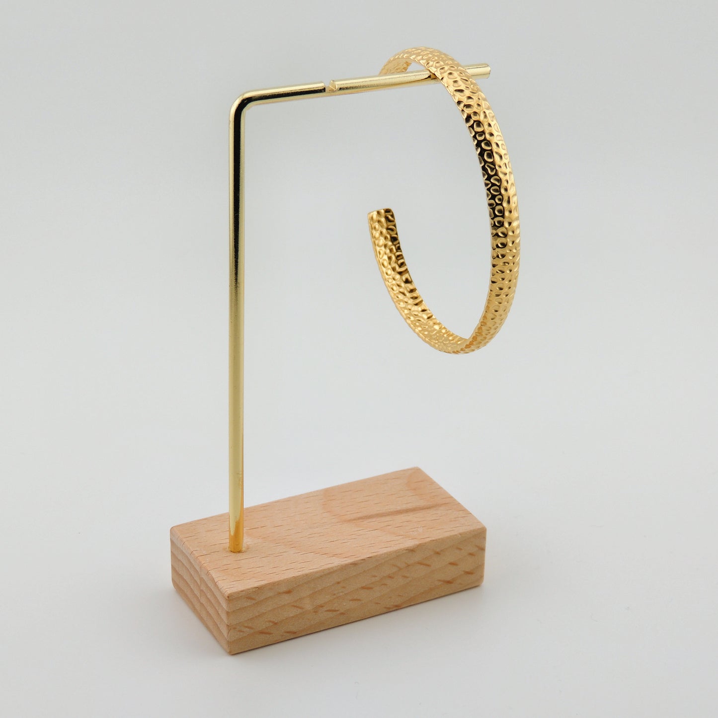 BRAZALETE NINES. Brazalete rígido ajustable de acero inoxidable bañado en oro de 18k