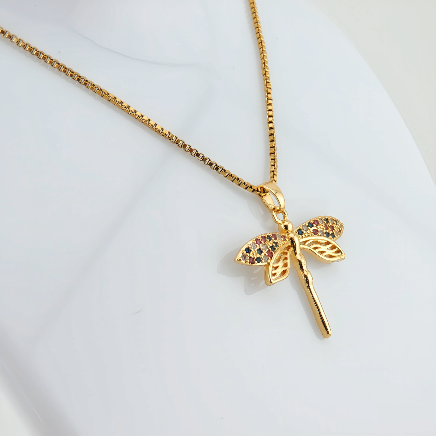 COLLAR GALATEA. Collar de acero inoxidable recubierto de titanio bañado en oro de 18k y colgante con forma de libélula con detalles de circonitas