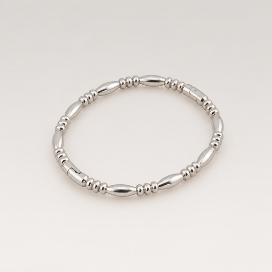 Brazalete elástico de acero inoxidable plateado con eslabones ovalados y cuentas pequeñas
