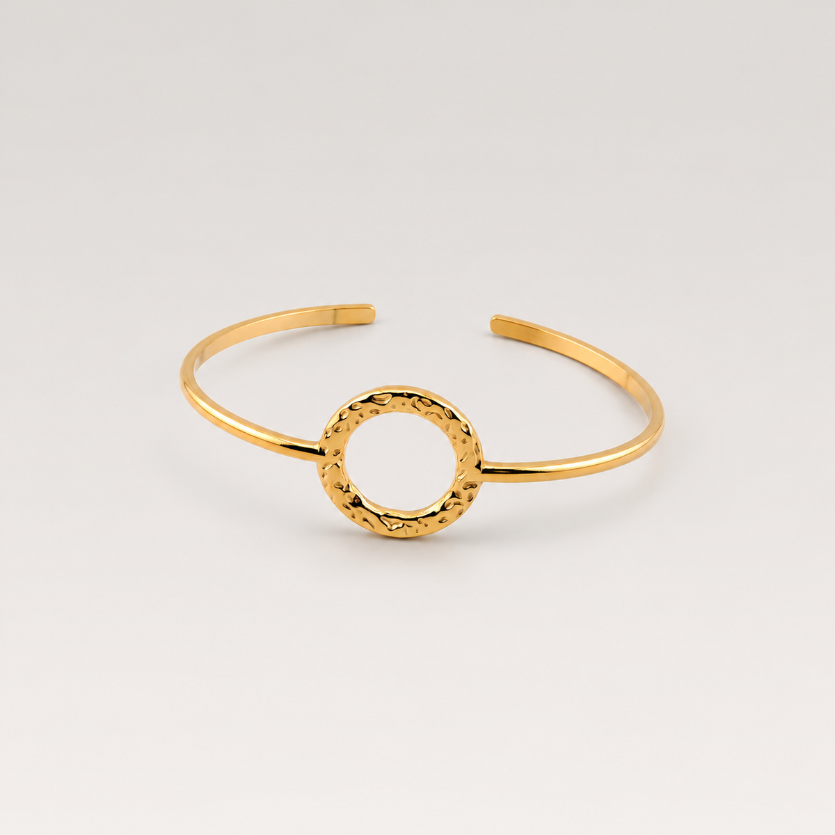 Brazalete rígido abierto de acero inoxidable bañado en oro de 18K con círculo martillado