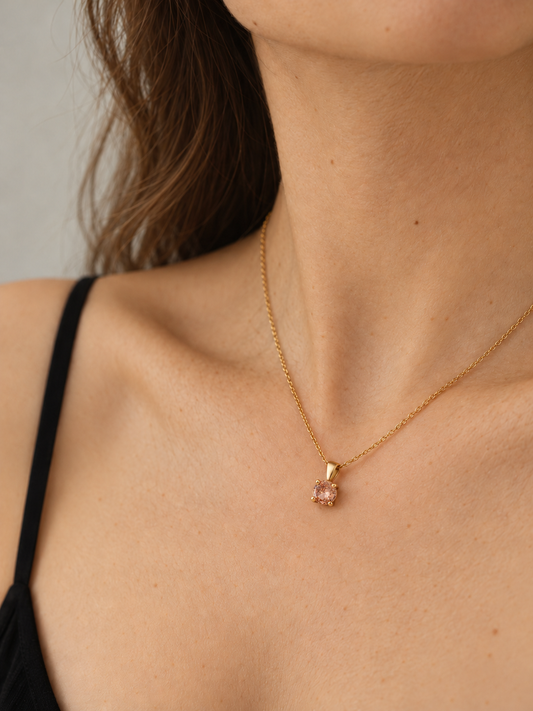 Collar fino bañado en oro de 18K con circonita rosa puesto con top negro de tirantes