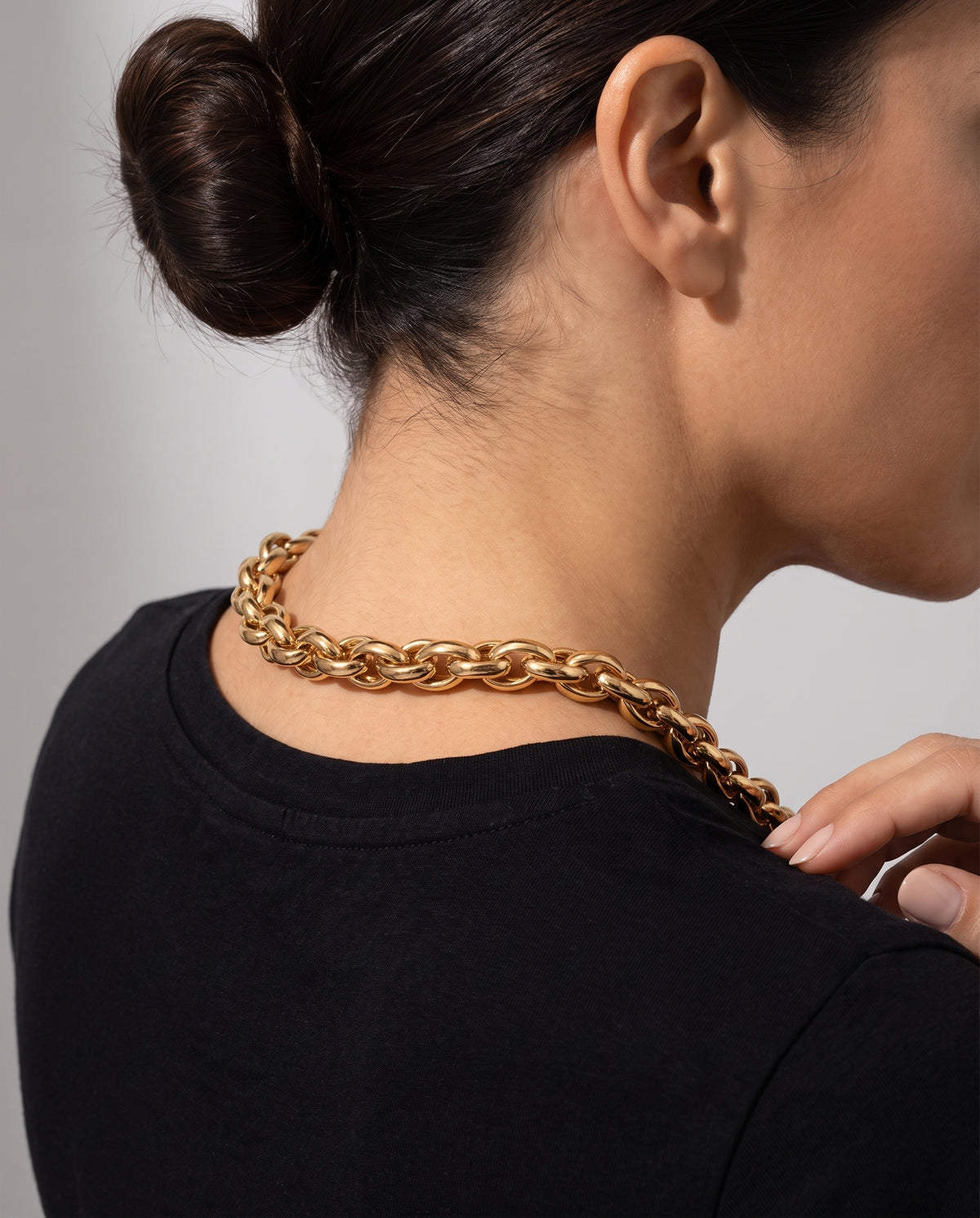 Collar Nala, cadena gruesa dorada de eslabón trenzado, puesta en la nuca de una mujer